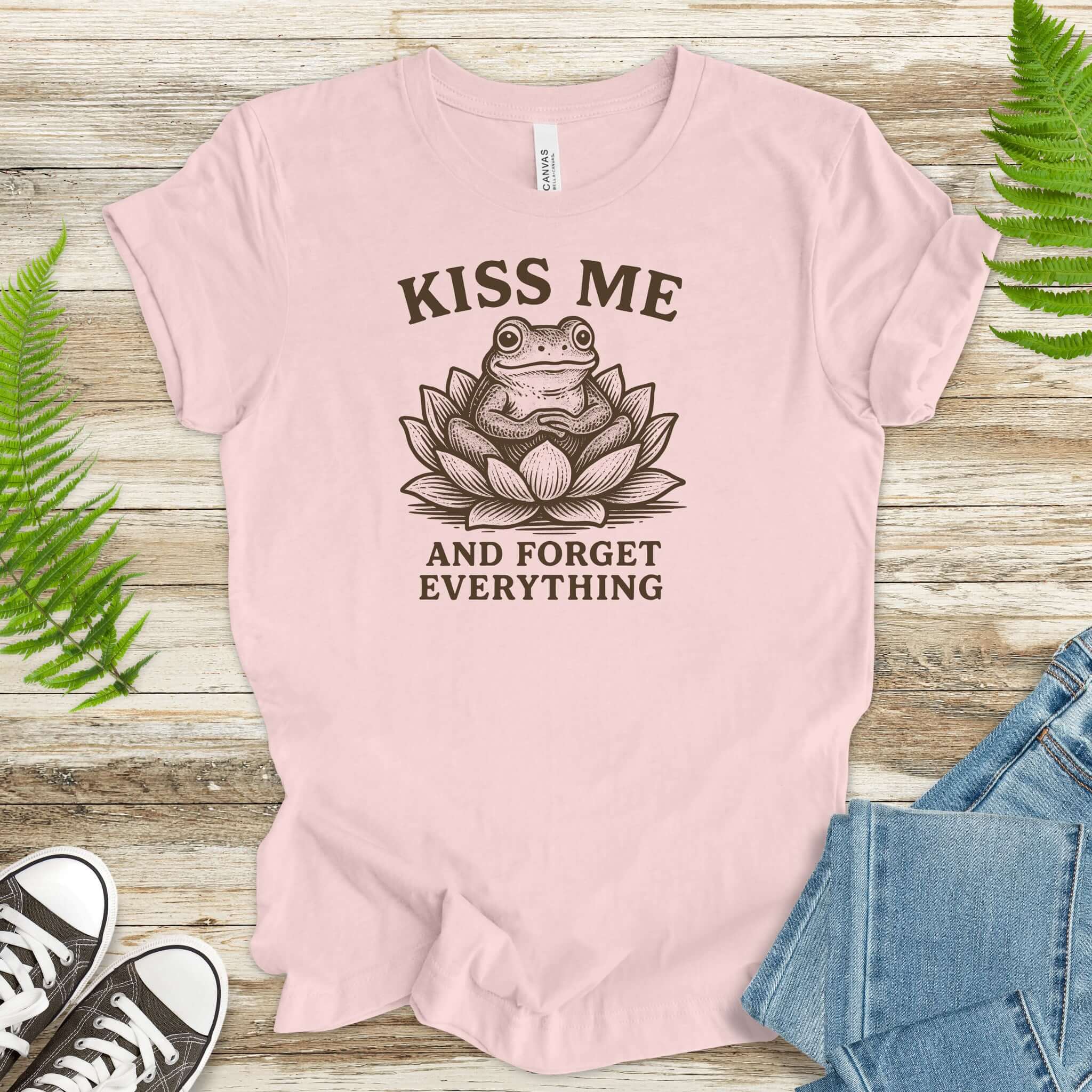 Funny frog in lotus flower graphic tee with 'Kiss Me and Forget Everything' text.