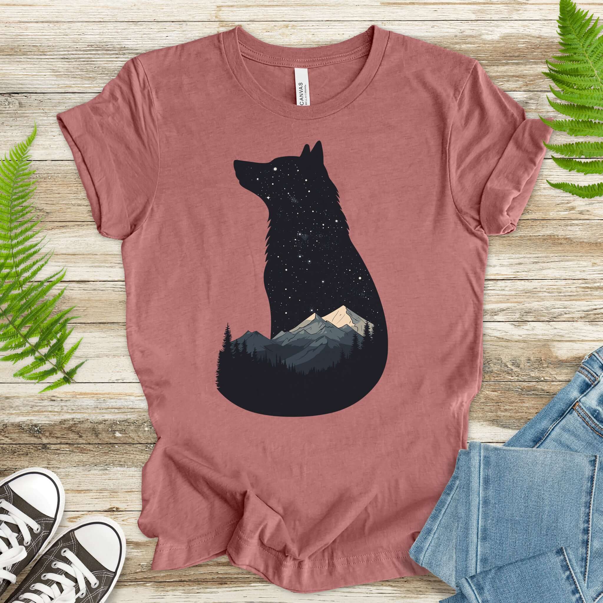Wolf silhouette t-shirt featuring night sky, mountains, and stars; perfect for nature lovers.